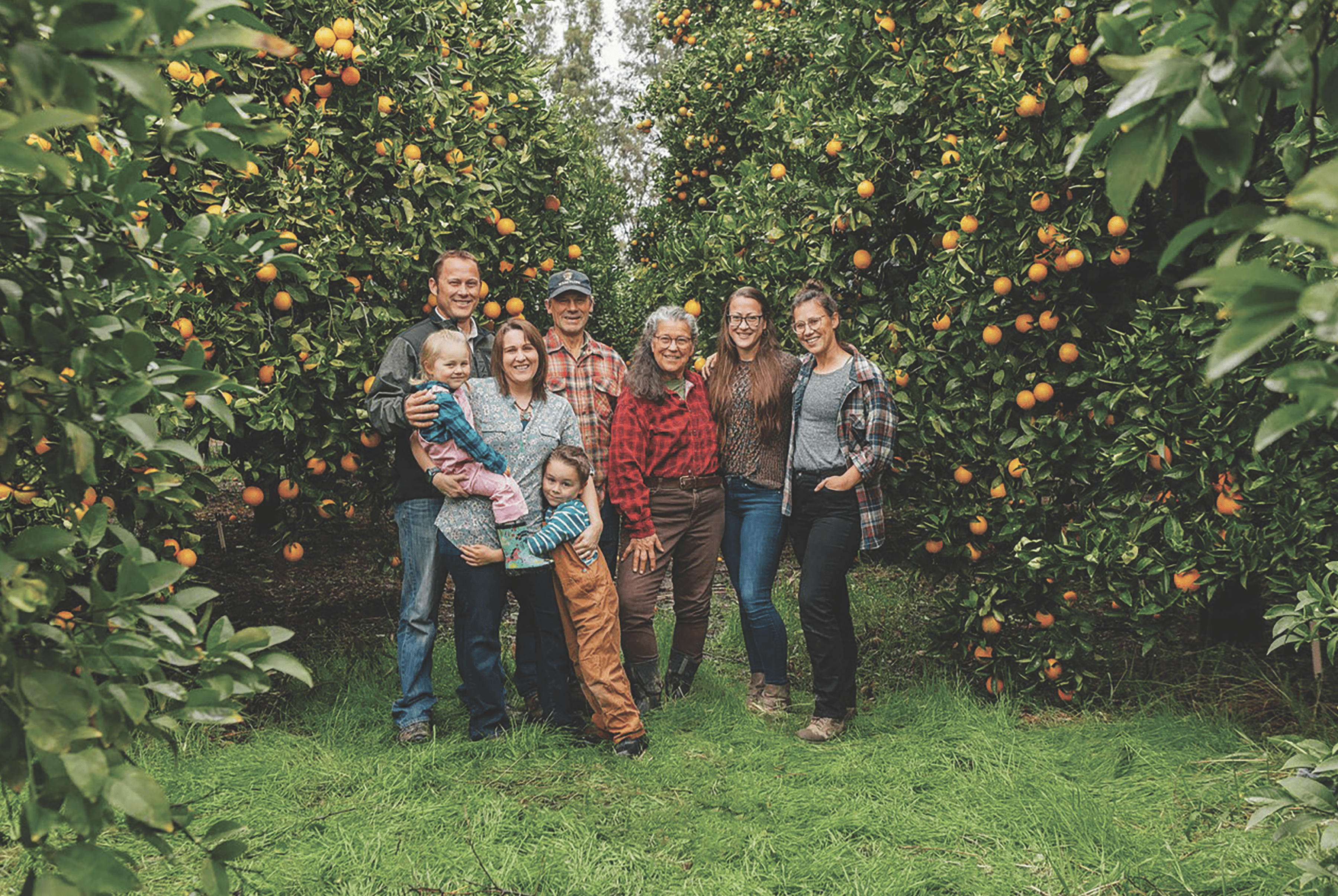 The Main family poses in their citrus grove on the Good Humus property. From left, son Zachary Main, and his wife, Nicole, and their children, Nolan and Zoe; Jeff and Annie Main; and daughters, Claire and Alison. (Photo by Raoul Ortega)